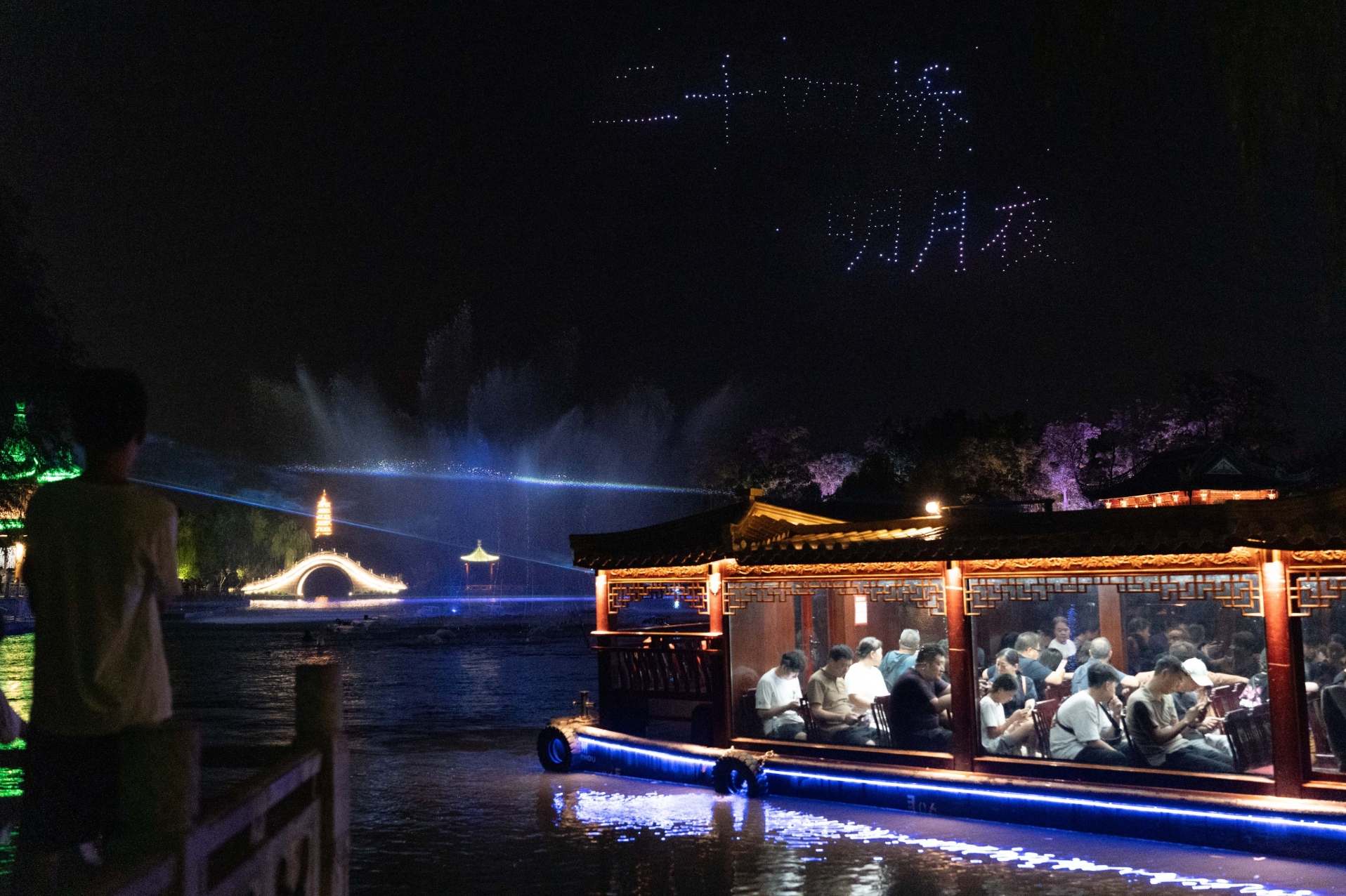 Night boats and projected words over a classical garden